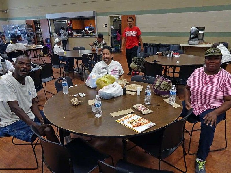 Guests seated at a table in the service hall with bags of groceries