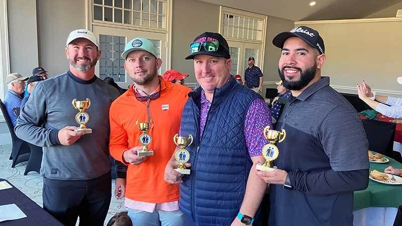 A winning foursome holding their trophies